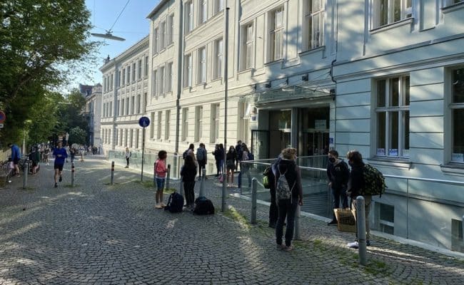 Schulkinder warten auf Einlass in die Schule zum Schulunterricht nach Corona-Pause