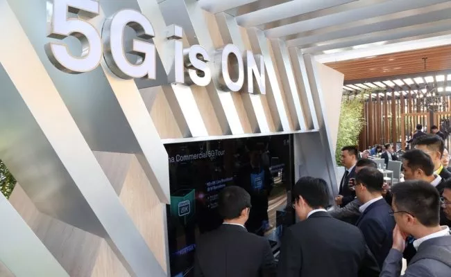 Besucher beim Mobile World Congress 2019 betrachten Display von Aussteller Huawei
