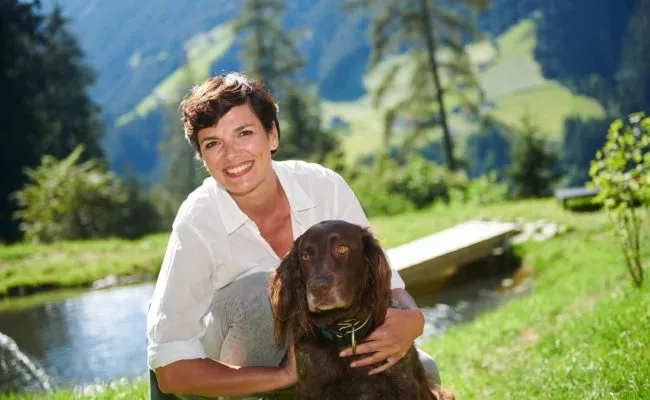 Pamela Rendi-Wagner umarmt einen Hund auf der Alm in Tirol