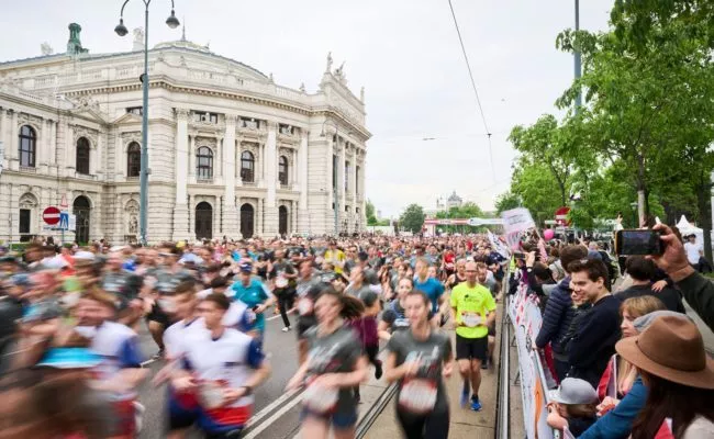 Teilnehmer am Wings for Life World Run in Wien passieren das Burgtheater am Ring.