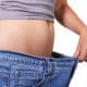 Stockfoto einer Person mit zu großer Jeans als Symbol für Gewichtsreduktion und Abnehmen.