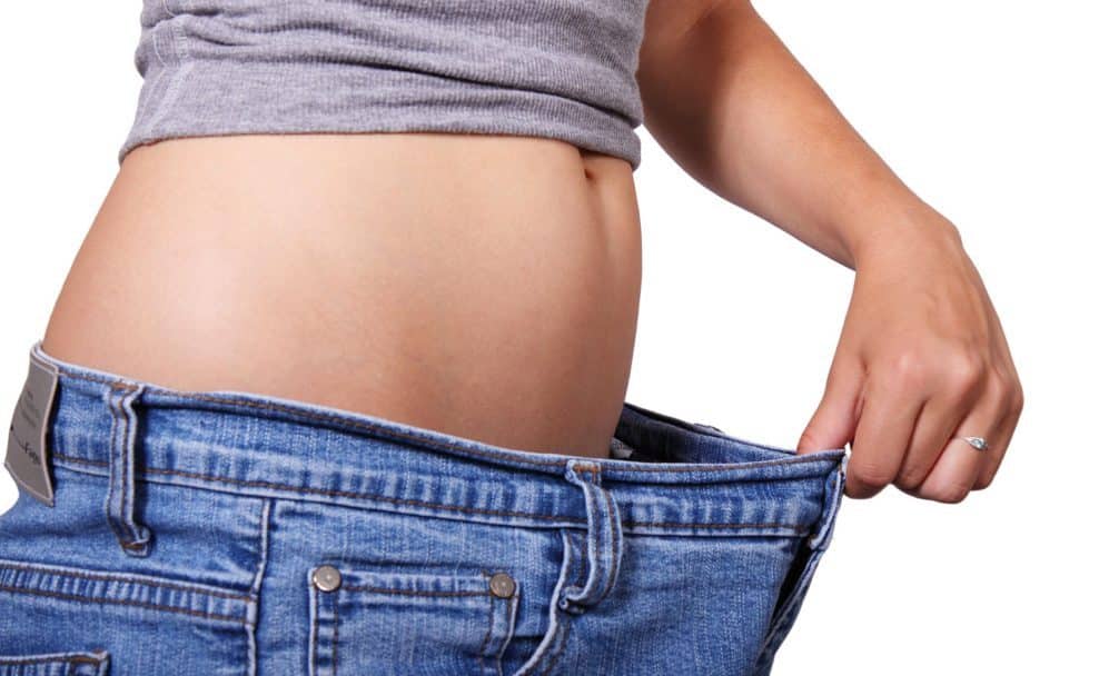 Stockfoto einer Person mit zu großer Jeans als Symbol für Gewichtsreduktion und Abnehmen.