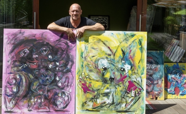 Jesse Magee vor zwei seiner farbenfrohen Werke beim Art Circle 2025 in St. Wolfgang.