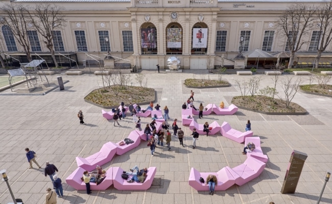 Balkonaufnahme mit rosa Enzis im Haupthof des MuseumsQuartiers Wien mit Besuchergruppen