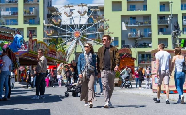 Familien und Besucher genießen Fahrgeschäfte im FunPark Graz bei Tag
