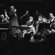 Herb Caruso singt mit Jazzensemble auf der Bühne während eines Konzerts