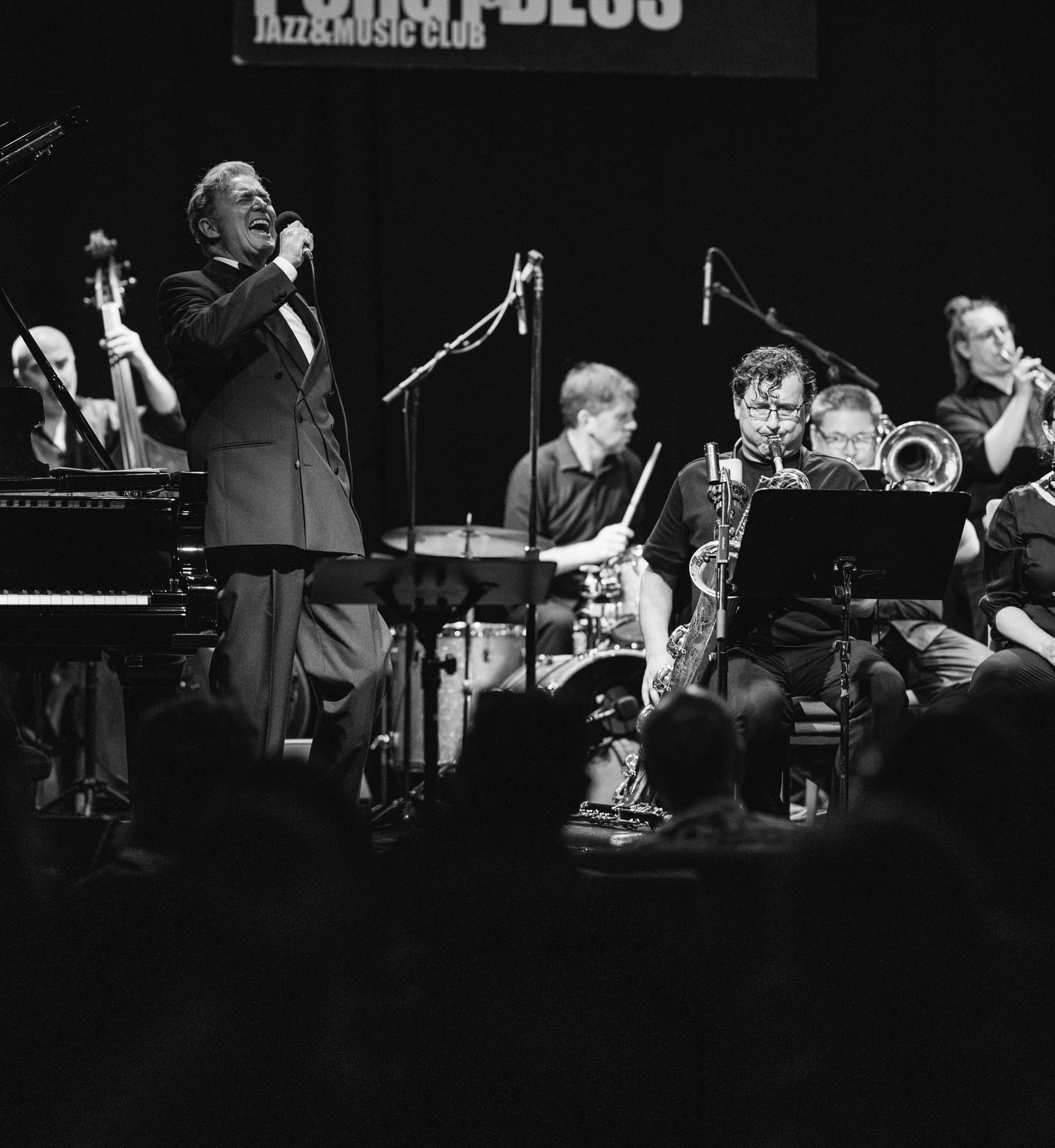 Herb Caruso singt mit Jazzensemble auf der Bühne während eines Konzerts