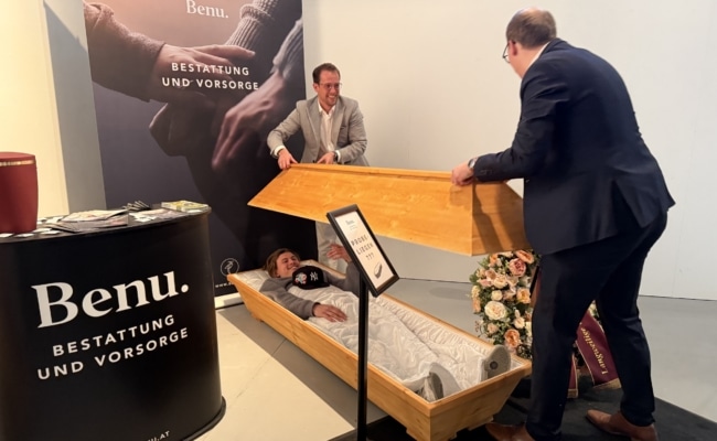 Gast liegt in ausgestelltem Benu-Sarg und macht Selfie bei Young Lions Veranstaltung