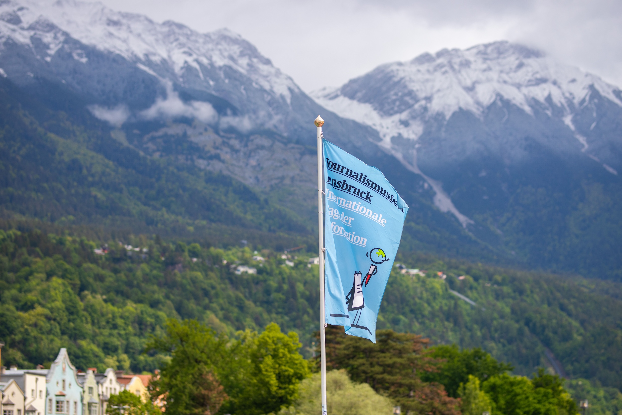 Fahne des Journalismusfests Innsbruck vor Alpenpanorama in Tirol