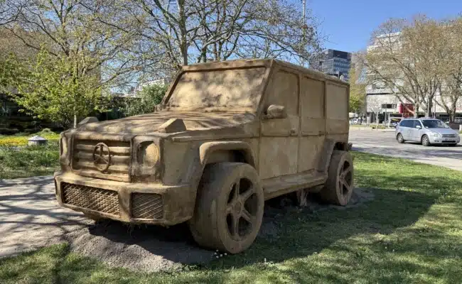 SUV-Skulptur aus Erde und natürlichen Materialien von Folke Köbberling im Wiener Stadtraum bei der Klima Biennale Wien 2026