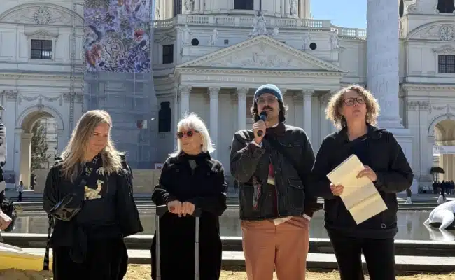 Kurator Hektor Peljak erläutert die Installation Kaorle am Karlsplatz 2026 von Margot Pilz vor der Karlskirche