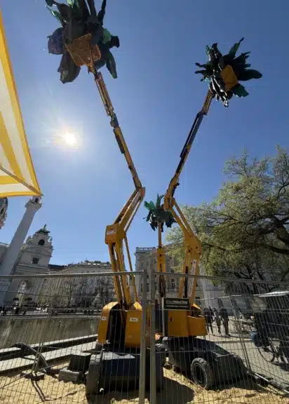 Installation Palmen am Karlsplatz von Pia Sirén mit Hebebühnen vor der Karlskirche während der Klima Biennale Wien 2026