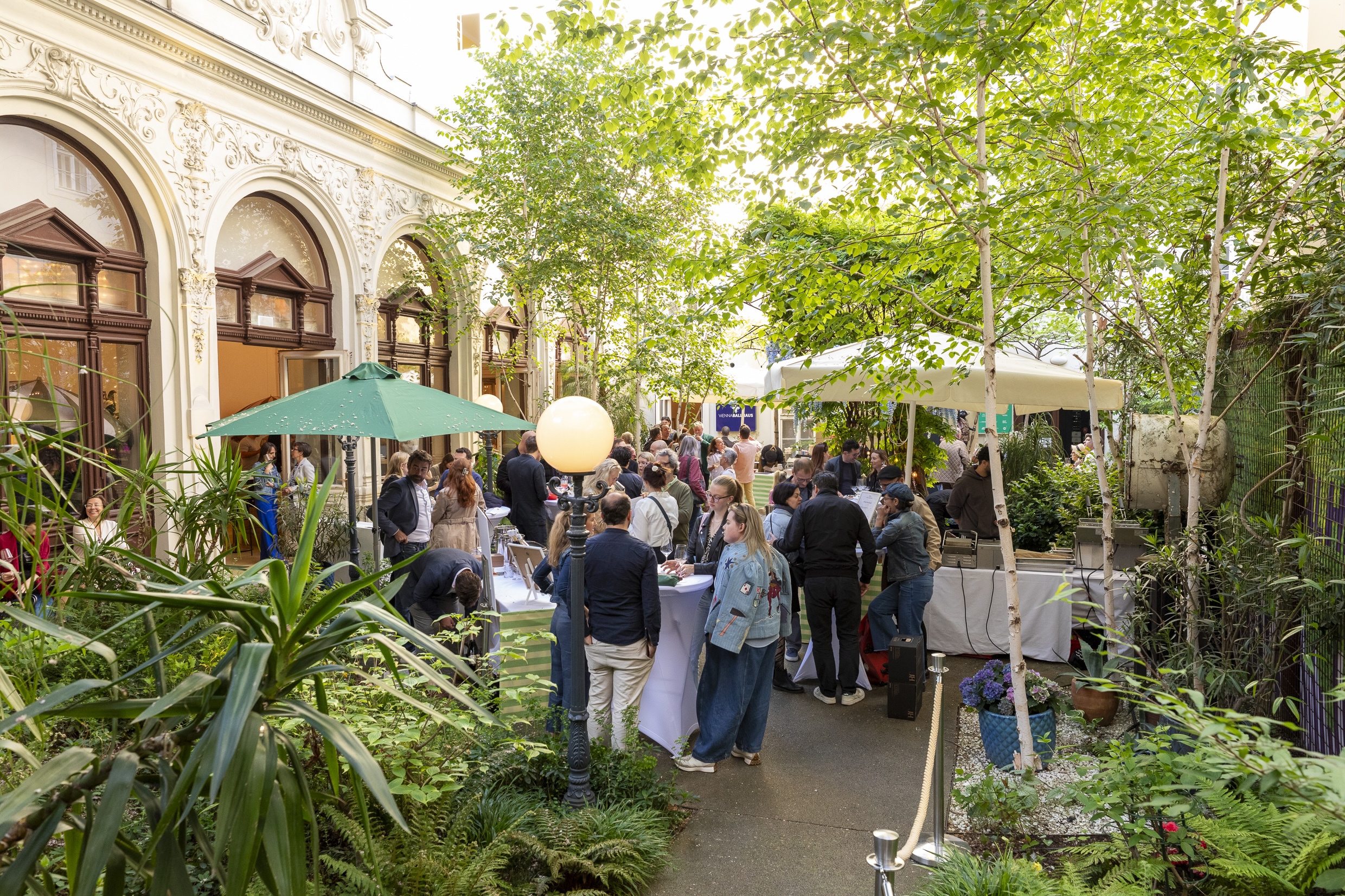 Gäste genießen Champagner im Garten des VIENNABallhaus bei TOTAL CHAMPAGNE