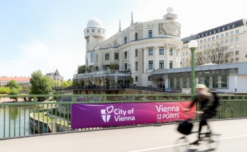 ESC-Banner der Stadt Wien auf einer Brücke über den Donaukanal vor der Wiener Urania