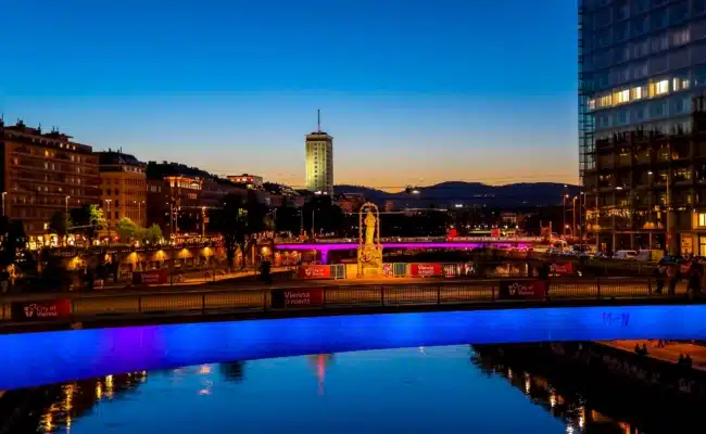Beleuchtete Donaukanal-Brücken in Wien in den Farben des Eurovision Song Contest bei Abendstimmung