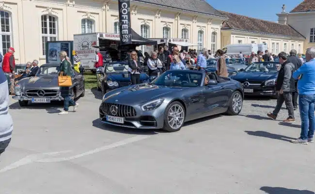Moderne Sportlichkeit zwischen klassischen Roadstern Mercedes-AMG GT Roadster fährt durch das Gelände des SL-Treffens im Schlosspark Laxenburg