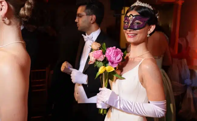 Debütantin mit Maske und Blumenstrauß beim Einzug in den Viennese Opera Ball New York
