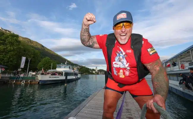 Extremkraftsportler Franz Müllner am Steg vor zwei Passagierschiffen der WolfgangseeSchifffahrt nach seinem Weltrekordversuch am Wolfgangsee.