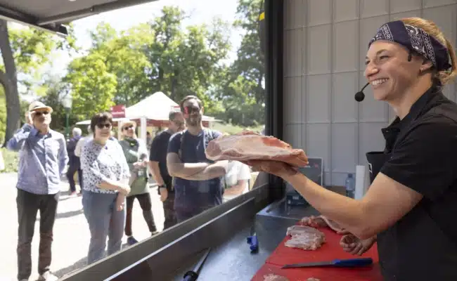 Mitarbeiterin präsentiert regionale Fleischspezialität beim GENUSS-FESTIVAL im Wiener Stadtpark