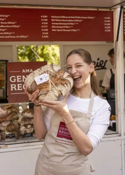 Mitarbeiterin mit regionalem Brot an einem Brotstand beim GENUSS-FESTIVAL in Wien
