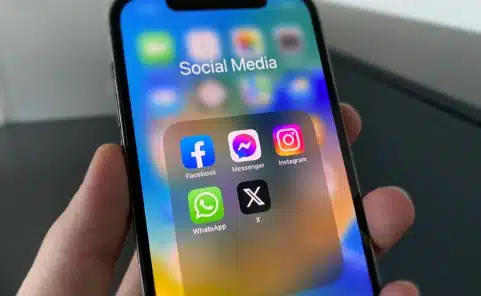 Smartphone mit Social-Media-Apps wie Facebook, Instagram und X auf dem Display