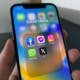 Smartphone mit Social-Media-Apps wie Facebook, Instagram und X auf dem Display
