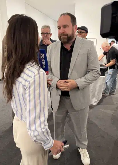 iFDD-Chef Christoph Haselmayer bei Interview mit Puls 24 in der Galerie Kaiblinger