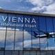 Flughafen Wien mit Flugzeug in einer Spiegelung am Terminalgebäude.