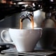Frisch gebrühter Espresso fließt aus einem Siebträger in eine Espressotasse.