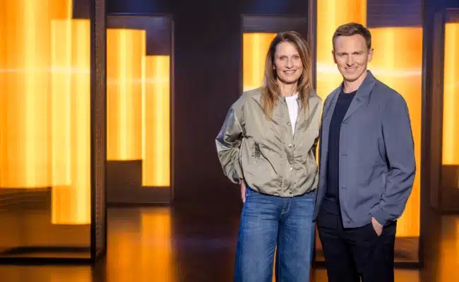 Katrin Müller-Hohenstein und Jochen Breyer stehen im ZDF-Studio zur Fußball-WM 2026.