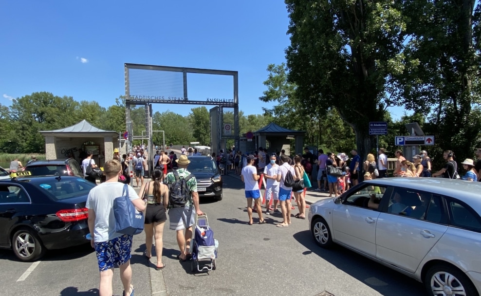 Badegäste vor dem Eingang des Gänsehäufels in Wien an einem stark besuchten Sommertag