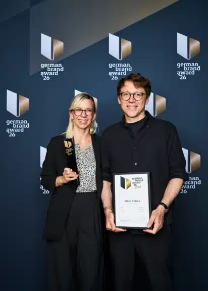 Jutta und Richard Ulmer von der Wiener Designagentur studio senseday mit Gold-Trophäe und Urkunde beim German Brand Award 2026 in Berlin.