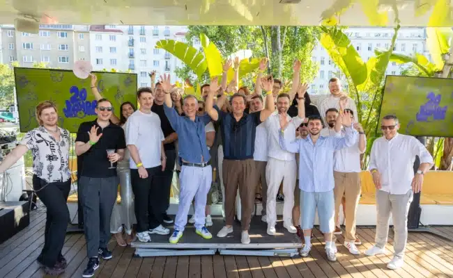 Team feiert 20 Jahre Unternehmensgeschichte Gruppenfoto des Teams von WEST4MEDIA beim Jubiläumsfest im Motto am Fluss in Wien.