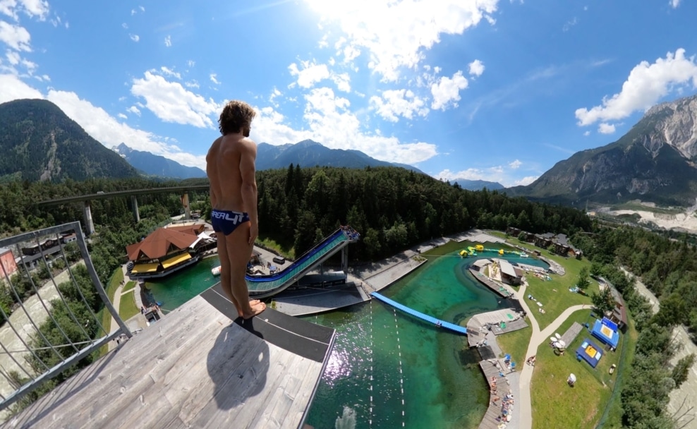 Cliff-Diver David Colturi auf der 27 Meter hohen Sprungplattform der AREA 47 vor der Bergkulisse des Ötztals