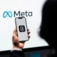 Smartphone mit Threads-App vor einem Bildschirm mit Meta-Logo als Symbolbild für den Meta-Konzern und seine Plattformen.