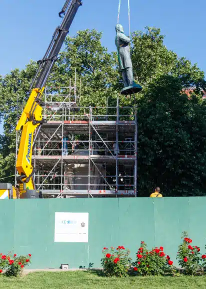 Die Bronzefigur des Lueger-Denkmals hängt während der Umbauarbeiten für die Intervention „Schieflage“ an einem Kran.