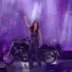 Andrea Berg steht beim Schlagerbooom Open Air 2026 vor einem Motorrad auf der Bühne im Stadion Kitzbühel und grüßt das Publikum.