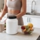 Nahrungsergänzungsmittel und Shake in einer modernen Küche neben frischem Obst.