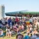 Besucher des Donauinselfests 2026 vor einem Gastronomiestand und auf der Wiese.