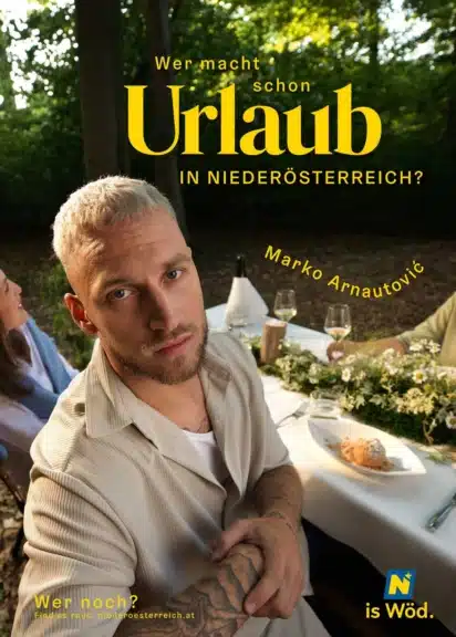 Marko Arnautović sitzt für die Urlaubskampagne der Niederösterreich Werbung an einer gedeckten Tafel im Wald.