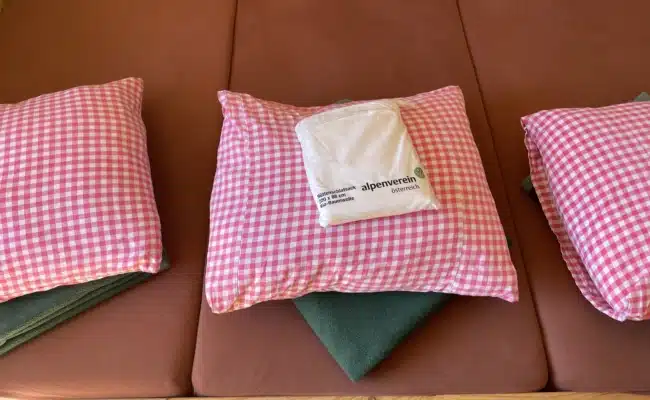 Matratzenlager mit Polstern und Hüttenschlafsack des Österreichischen Alpenvereins.
