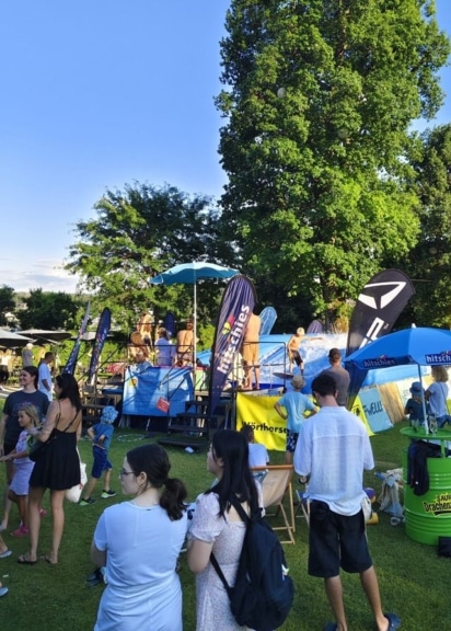 Besucher verfolgen die Surfdays an der mobilen Surfwelle im Kurpark Velden am Wörthersee