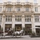 Außenansicht des Steigenberger Hotel Herrenhof Wien mit Fiaker in der Herrengasse.