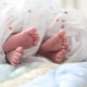 Füße von Neugeborenen unter einer Babydecke als Symbolbild für die beliebtesten Babynamen Emma und Noah in Österreich 2025.