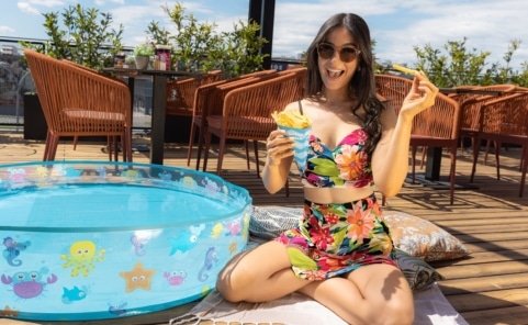 Junge Frau genießt Churros im Sommer auf einer Terrasse