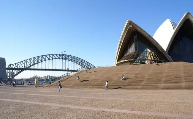 Touristen vor dem Sydney Opera House und der Harbour Bridge an einem sonnigen Tag
