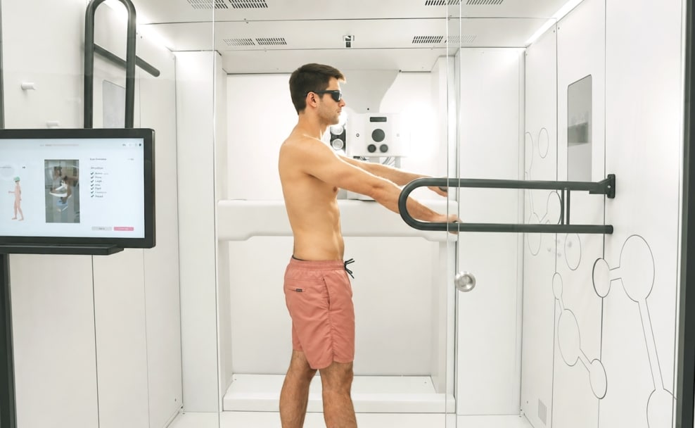 Ein Mann steht mit Schutzbrille im Ganzkörperscanner Deviskan zur digitalen Kontrolle seiner Haut.