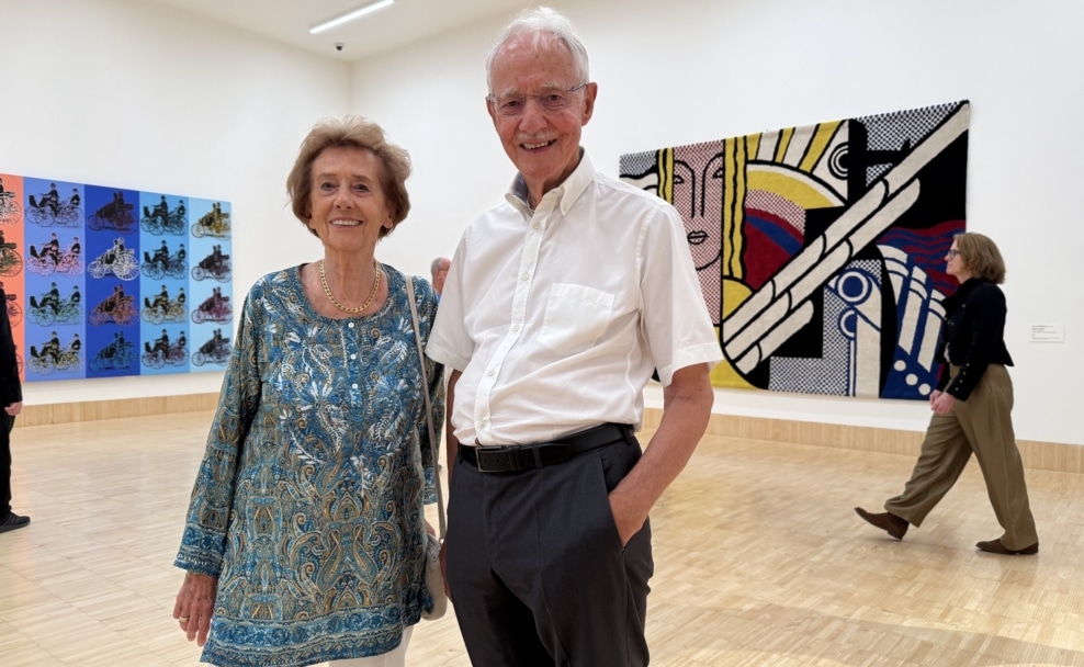 Agnes und Karlheinz Essl lächelnd vor Roy Lichtensteins „Modern Tapestry“ in der ALBERTINA Klosterneuburg