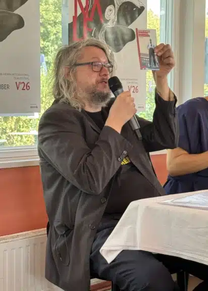 Christoph Huber hält bei der Viennale-Pressekonferenz das Cover seines Robert-Aldrich-Buches hoch