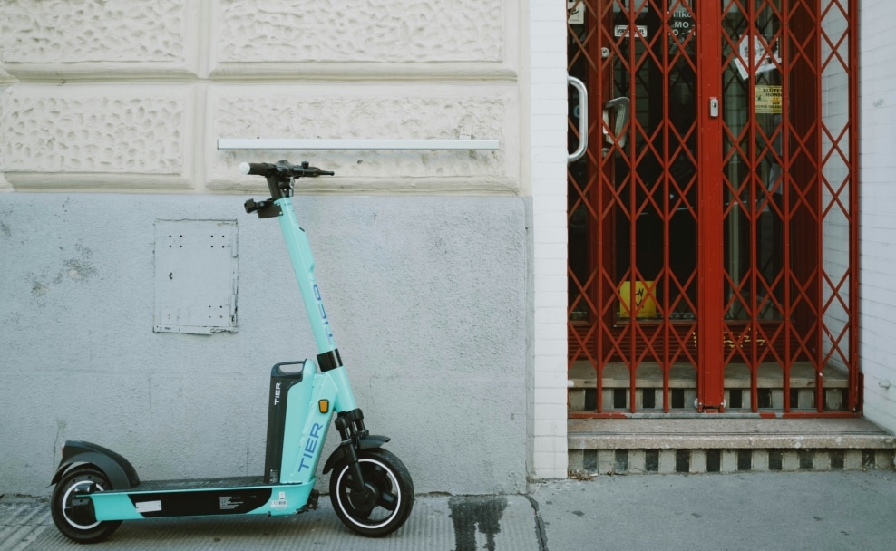 Türkiser Leih-E-Scooter vor einer Hausfassade in Wien